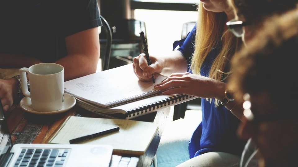 Nhóm làm việc họp bàn quanh bàn với máy tính xách tay và tài liệu